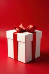 Fototapeta premium White gift box with red bow, red background Festive holiday present , Valentine's Day, Christmas