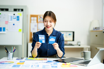 designer holds wireframe cards while planning UX/UI in a creative office, showcasing innovation,...