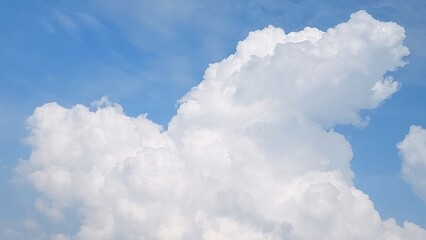White clouds scattered across the blue sky with daylight natural background. Blue sky with clouds. Soft white clouds float in the clear blue sky. Clear blue sky, bright spring.