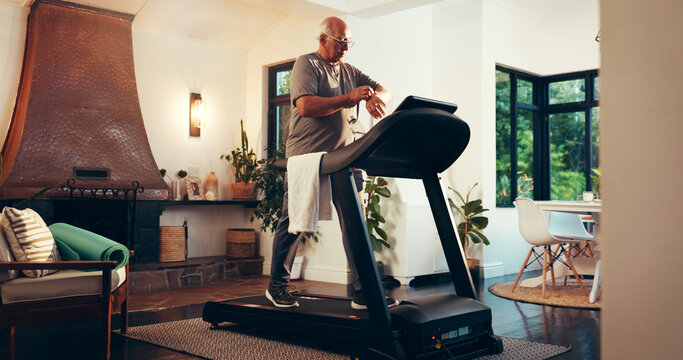 Senior man, treadmill or monitor watch in home for walking speed, cardio stats or burn calories. Retirement fitness, old person and check stopwatch on machine for exercise data and mobility wellness
