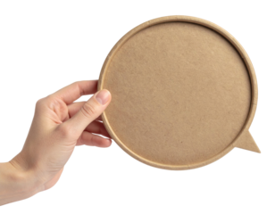 A hand holding a round, brown cardboard speech bubble with a small triangular pointer on the side.