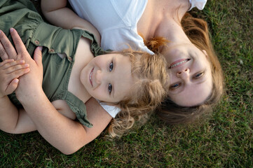 Mother and daughter lying in the grass.