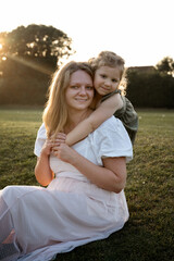 Little girl hugging her mother in the park.