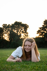 Woman resting alone in the grass at sunset.