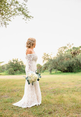 Bride in Lace Wedding Dress Holding Bouquet Negative Space Right