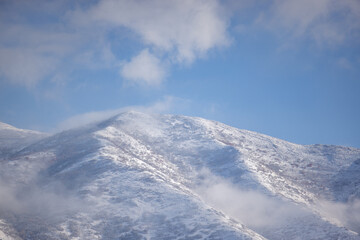 Snow-covered Utah mountain beneath a bright blue sky