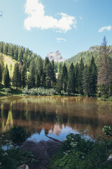 A serene mountain lake reflects the stunning Dolomites landscape, offering a peaceful view.