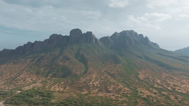 Drone view of rocky desert mountain and valley at sunset