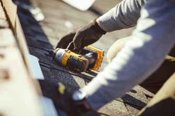 A close-up of the drill lying on the roof next to the roofer © Cavan