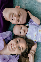 Smiling family lying on blanket with baby girl