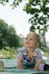 Smiling baby crawling with bubbles in the air