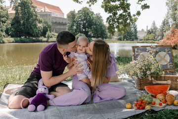 Young family enjoying summer picnic with baby