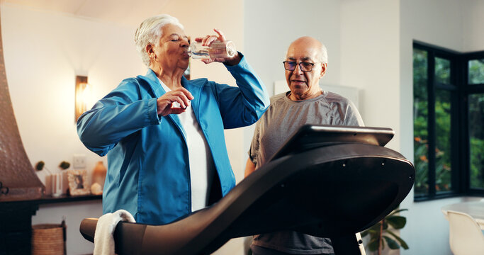 Senior woman, treadmill and drinking water in home for training, rest or hydration in retirement. Elderly man, couple and partner with bottle, gym equipment and exercise machine with support at house