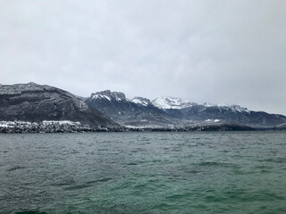views from the shore of lake annecy after the last snowfall