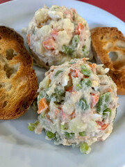 plate of Russian salad accompanied by slices of toast