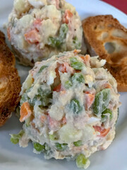 plate of Russian salad accompanied by slices of toast