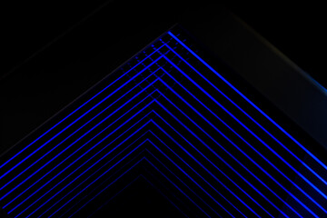 minimalist interior featuring blue neon lights. The lights create a grid pattern against a dark...