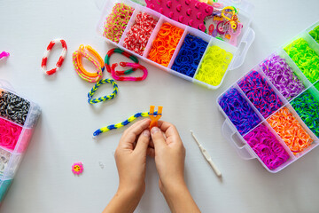 Child making colorful rubber band bracelets