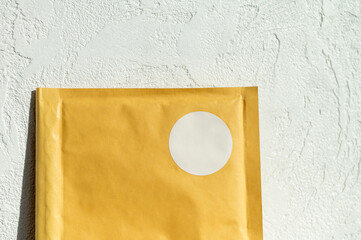 Brown paper envelope with white sticker on textured wall background