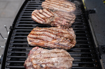 Juicy steaks grilling on outdoor bbq with smoky aroma