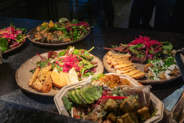 Assorted vegan dishes with fresh salads and grilled vegetables on rustic plates