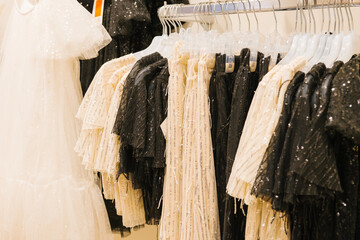 Elegant white and black sequined dresses on display in a fashion boutique