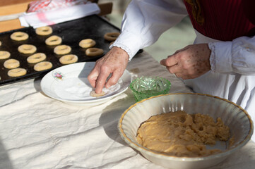 woman's hands preparing dough to make sweet rolls with typical costumes