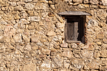 wooden window recessed in a stone wall
