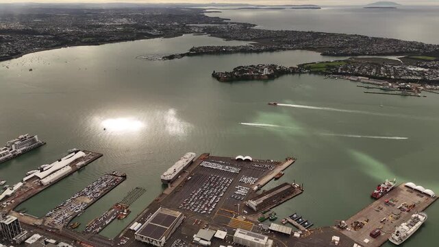 Port of Auckland with ferries and cargo ships, New Zealand. Aerial forward