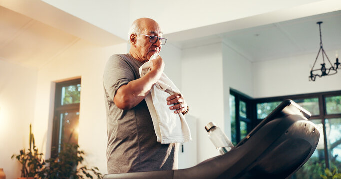 Treadmill, senior man and towel for exercise break, tired and training recovery in home. Cardio machine, wipe sweat and person rest for wellness, health and fitness with fatigue in retirement