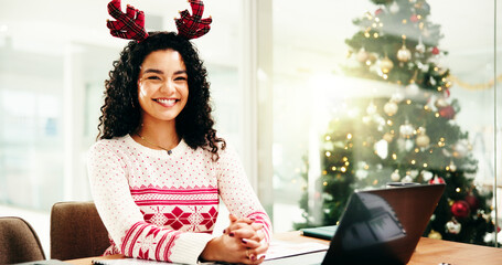 Woman, smile and laptop at Christmas in office with portrait, pride or festive sweater at company. Person, computer and writer with reindeer hat, happy and xmas jersey at creative agency in Colombia