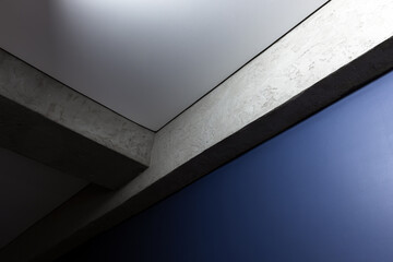 Modern architecture featuring a textured concrete beam and elegant blue wall