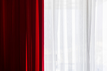 A contrasting display of vibrant red and airy white curtains