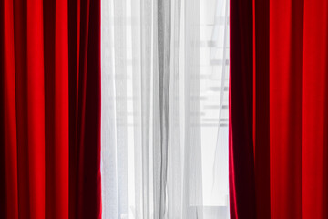 Vibrant red and airy white curtains lit by natural sunlight