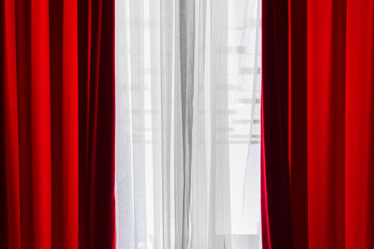 Vibrant red and airy white curtains lit by natural sunlight