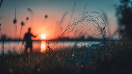 Silhouette of a person at sunset near a fishing net.
