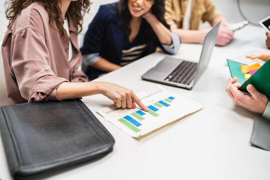 Marketing team engaging in a discussion about a financial chart during a collaborative business meeting in a modern coworking office