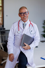 Portrait of handsome male doctor with stethoscope over neck working while looking at camera in the...