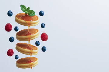 Fluffy pancakes stacked with syrup, garnished with fresh mint, blueberries, and raspberries create delightful breakfast scene. vibrant berries add pop of color with copy space