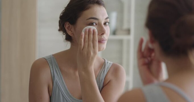 Woman cleaning skin with cotton pad