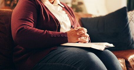Religion, hands and bible with old woman on sofa for worship, gratitude and peace. Praying,...