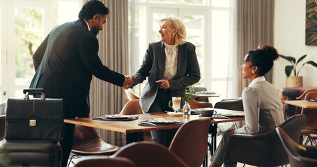 Handshake, smile and business people in cafe, hello and support with luggage, agreement and...