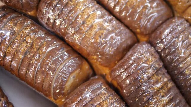 Loaves of sliced bread or a loaf standing in a row. Finished sliced product.
