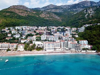 A drone photo on a beach in Sveti Stefan and in the background with bars restaurants hotels in...