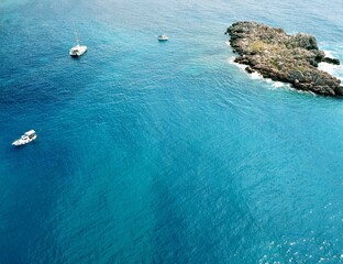 A drone photo from above of small yachts in the water in Sveti Stefan Montenegro