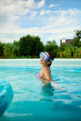 Girl enjoying a sunny summer day in a pool, wearing snorkeling gear and having fun in clear water