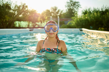 Teen girl enjoys swimming in a backyard pool during a sunny summer afternoon