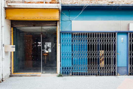 Devantures de magasins jaune et bleu abandonn&eacute;s. Faillite de petits commerces. Mondialisation. Porte de magasin ferm&eacute;. Vitrines abandonn&eacute;es. Anciennes fa&ccedil;ades.