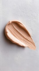 Beige Foundation Smear on Textured Gray Surface – Artistic Close-Up of Makeup Texture Highlighting Creamy and Powdery Beauty Product