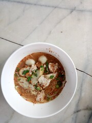 Delicious Tom Yum Noodles: Pork, Fish Balls, and Herbs.